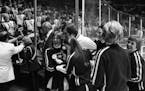Richfield High School hockey coach Larry Hendrickson with cheerleaders in front of the school band following the team's semi-final win over Bemidji at