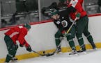 Tyler Ennis, Brennan Menell and Eric Staal (left to right) battled for a loose puck in the corner during the Wild's training camp in 2017