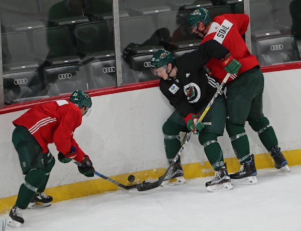 Tyler Ennis, Brennan Menell and Eric Staal (left to right) battled for a loose puck in the corner during the Wild's training camp in 2017
