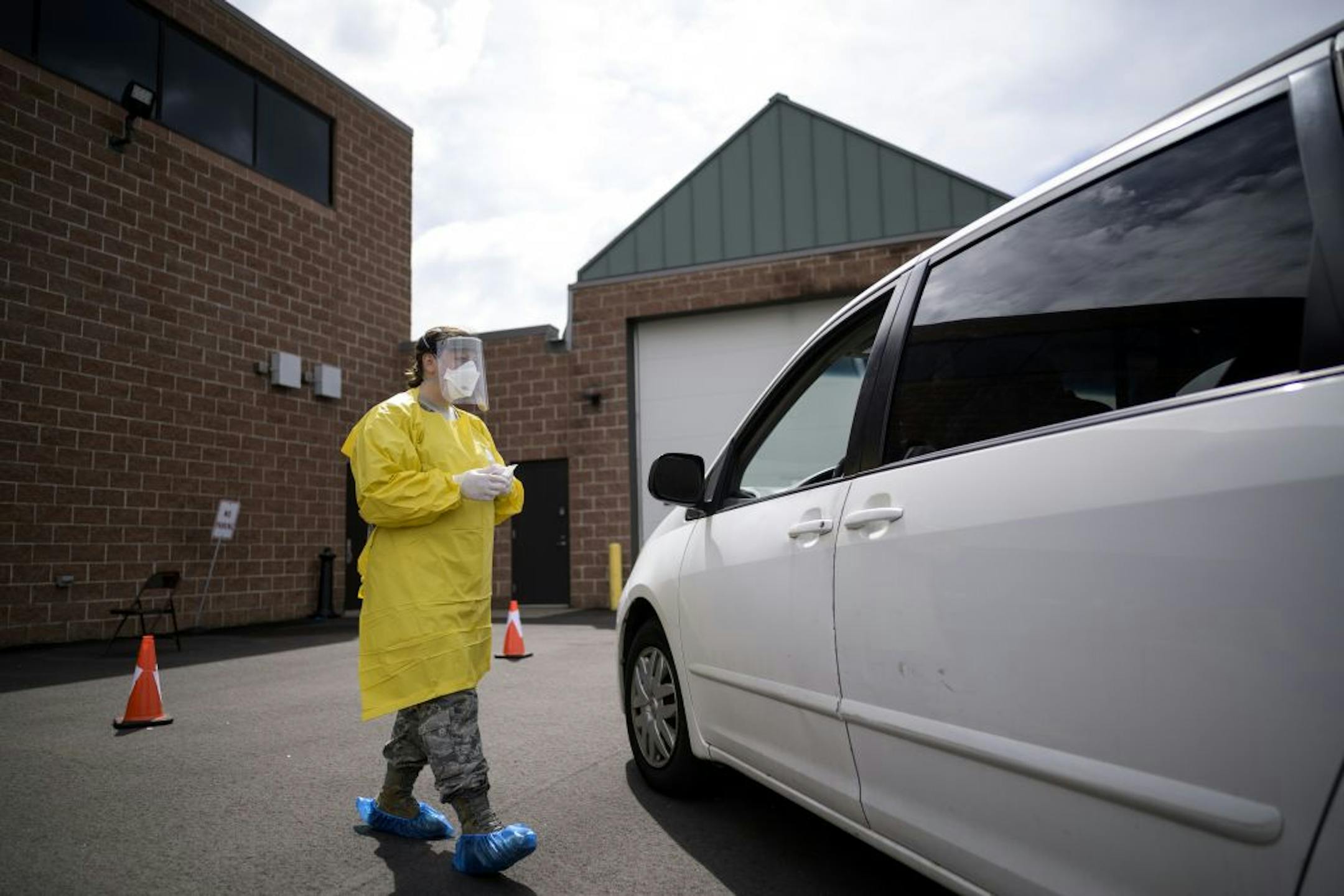 Kristin Anderson, a medic with the Minnesota Air National Guard's 133rd Medical Group, approached a car to administer COVID-19 tests Saturday.