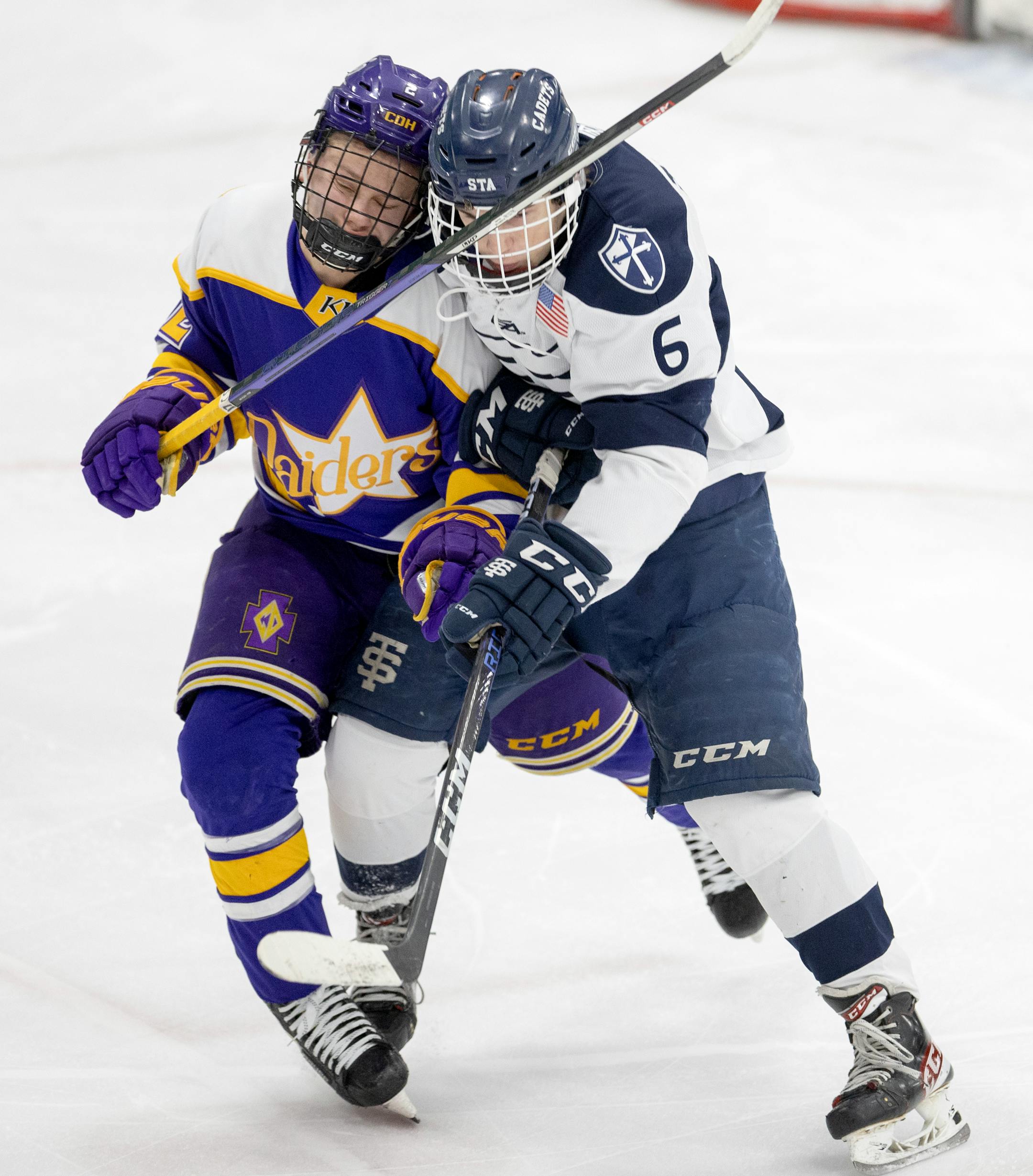 Luke McCarthy (2) of Cretin-Derham Hall and Jordan Tacheny (6) of St. Thomas Academy fight for position in the first period.