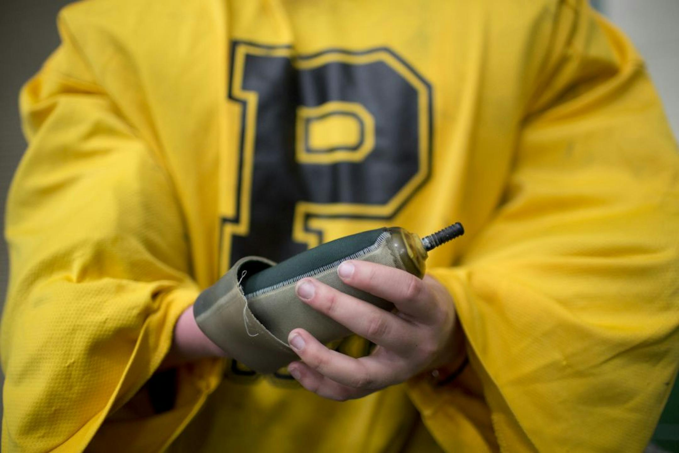 Caitlin Tate, a senior at Park of Cottage Grove High School, is the starting goalie on her school's hockey team despite not having a right hand since birth. The team worked out after school Monday, November 12, 2012 at the arena next door to the high school. Caitlin Tate showed the piece of gear she wears on her right forearm that fits inside a prosthesis that allows her to hold onto a goalie glove.