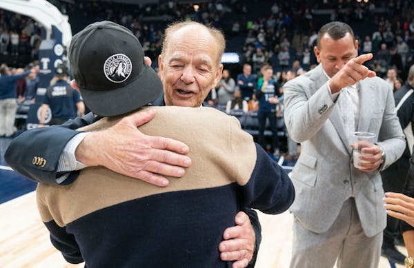Minnesota Timberwolves majority owner Glen Taylor hugs minority share owner Marc Lore while Alex Rodriguez looks on after the team’s win over the Cl