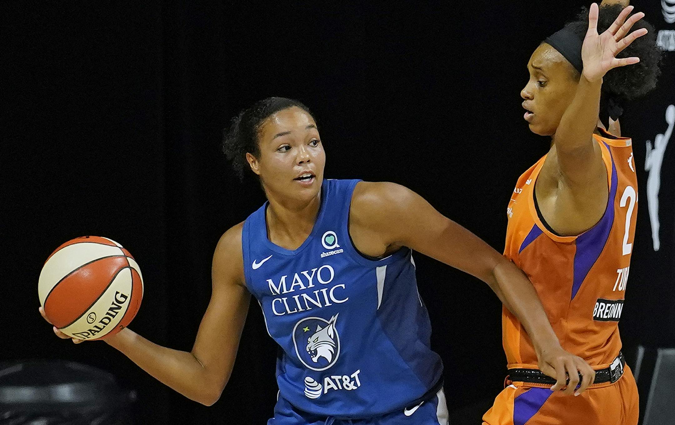 Minnesota Lynx forward Napheesa Collier (24) passes around Phoenix Mercury forward Brianna Turner (21) during the first half of a WNBA playoff basketball game Thursday, Sept. 17, 2020, in Bradenton, Fla. (AP Photo/Chris O'Meara)
