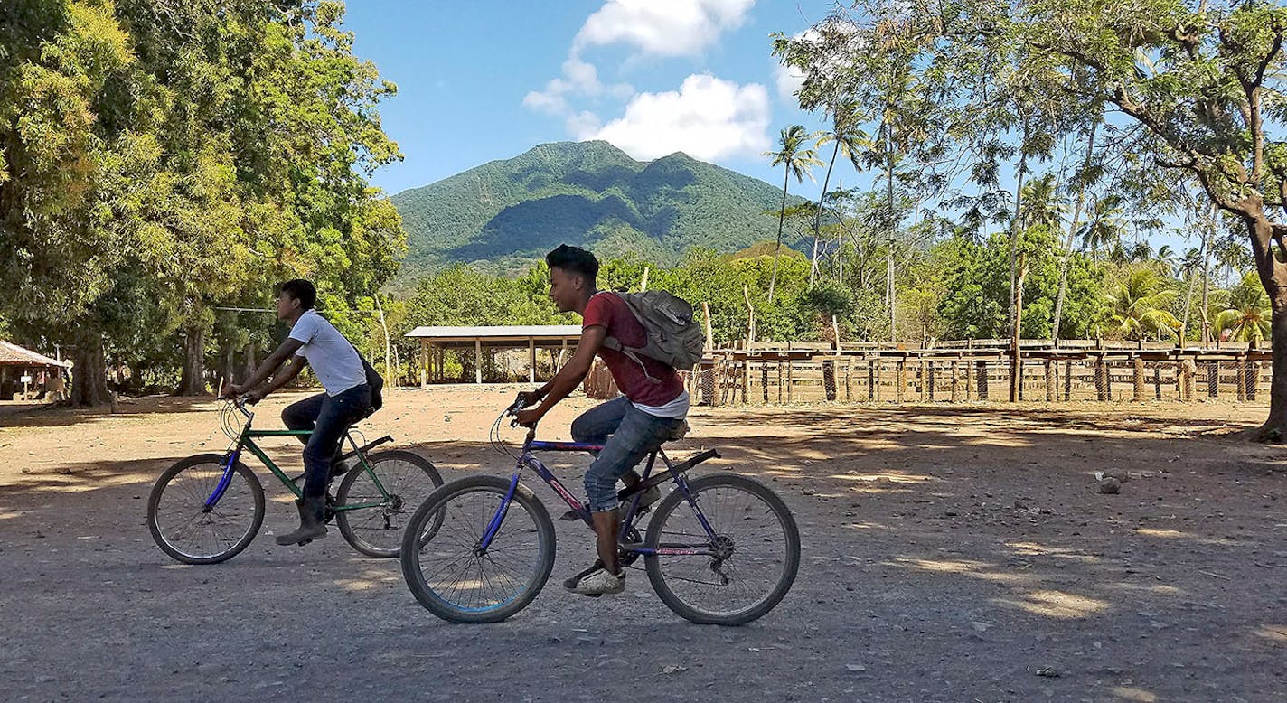 Teenagers ride bicycles in the village of Merida near the dormant volcano Maderas, on the more remote side of the island of Ometepe in Nicaragua.