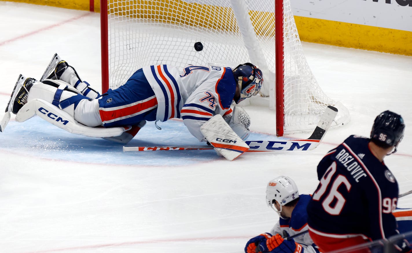 Columbus Blue Jackets forward Jack Roslovic, right, scores past Edmonton Oilers goalie Stuart Skinner, left, and defenseman Evan Bouchard during the third period of an NHL hockey game in Columbus, Ohio, Saturday, Feb. 25, 2023. The Blue Jackets won 6-5. (AP Photo/Paul Vernon)