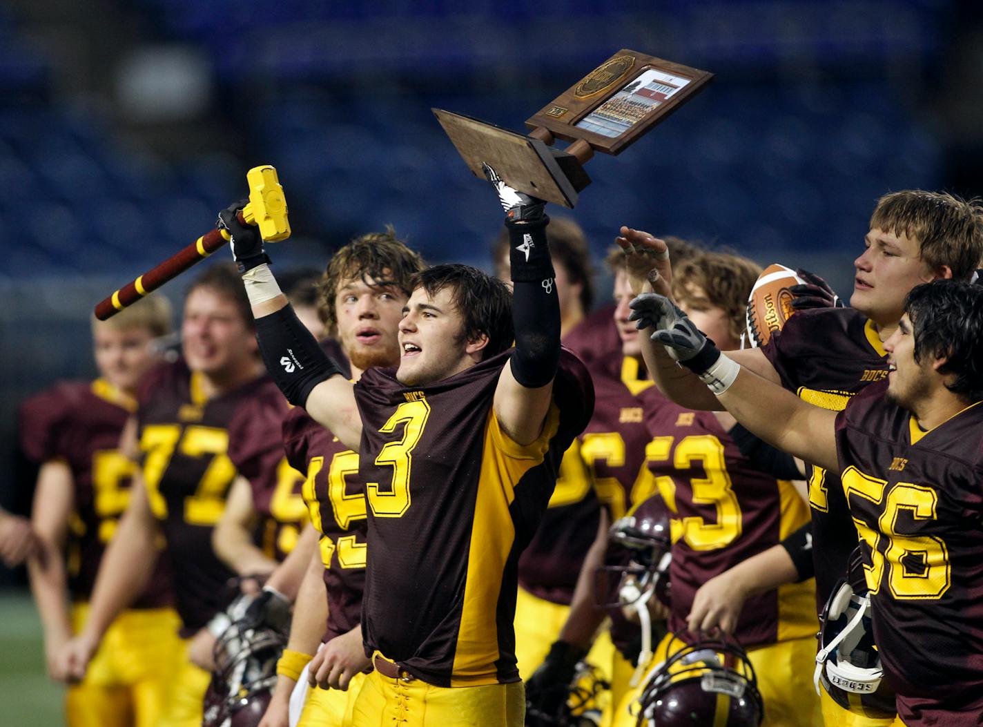 Surrounded by teammates Blue Earth Area's Chandler Kienitz (3) held the team trophy following Blue Earth's 30-7 win over Rochester Lourdes at the 3A Prep Bowl championship at the Metrodome Saturday, Nov. 24, 2012, in Minneapolis, MN.] (DAVID JOLES/STARTRIBUNE) djoles@startribune.com Rochester Lourdes and Blue Earth Area during quarter action at the 3A Prep Bowl championship at the Metrodome Saturday, Nov. 24, 2012, in Minneapolis, MN.