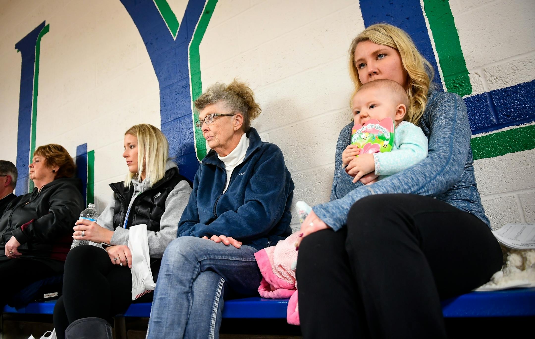 Diane Trytten, center, sat next to her granddaughters, Amber Witt, left, Haley Williamson, right, and great granddaughter, 7-month old Grace Williamson, as they watched Friday night's junior varsity basketball game between Grand Meadow and Lyle-Pacelli. Trytten voted for Hillary Clinton in the last presidential election but neither Amber or Williamson voted.