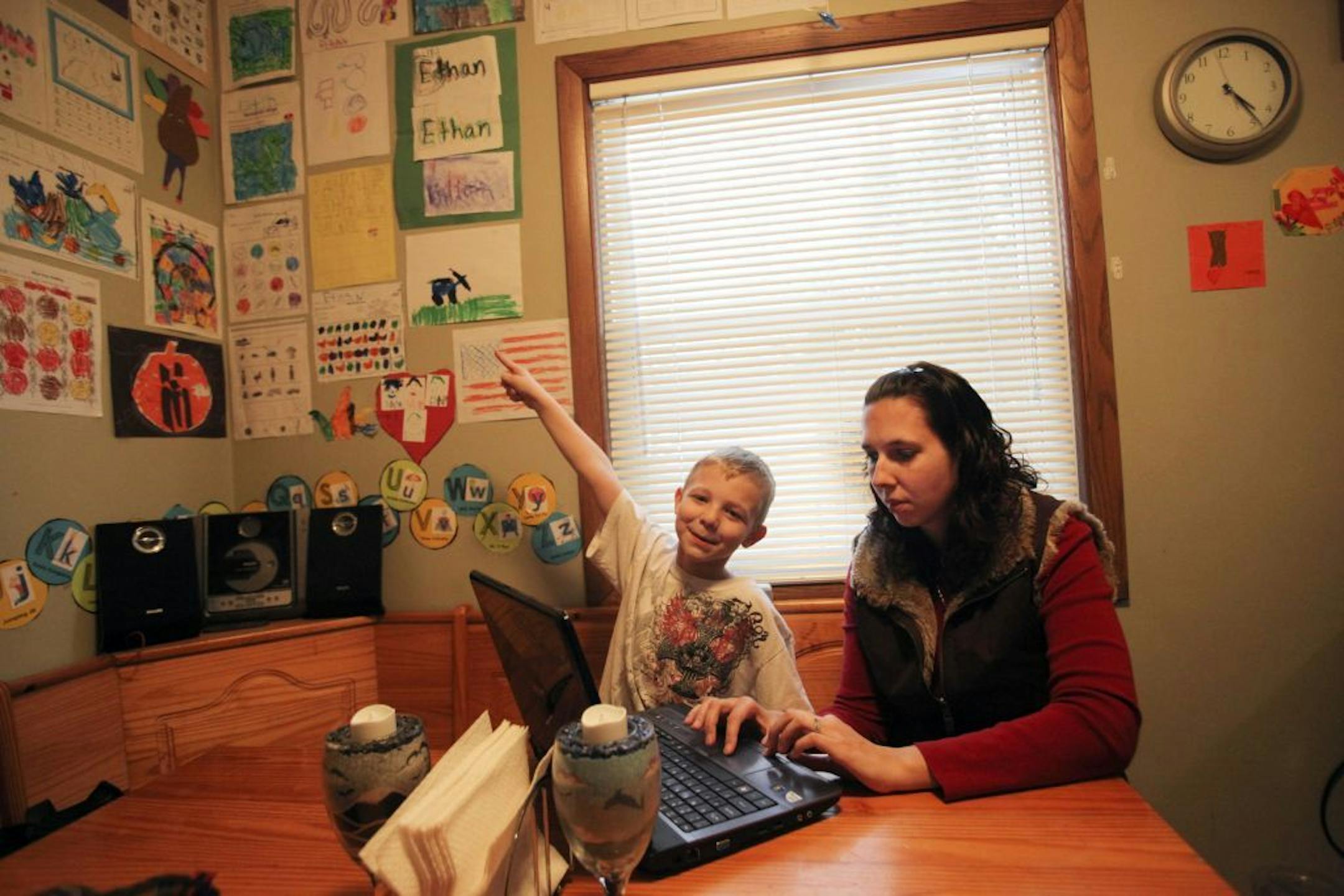 Stacey Hunt is a former staff sgt. with the Minnesota National Guard who is pursuing a disability claim with the VA for an ankle injury suffered during her service. She was photographed at her home with her son Ethan, 6, as she searched her facebook page for a photo of herself during her service in Iraq Tuesday Jan. 29, 2013, in White Bear Lake, MN.