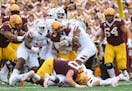 Minnesota Gophers quarterback Tanner Morgan (2) was tackled by a host of Bowling Green Falcons defenders during a rush in the second quarter.