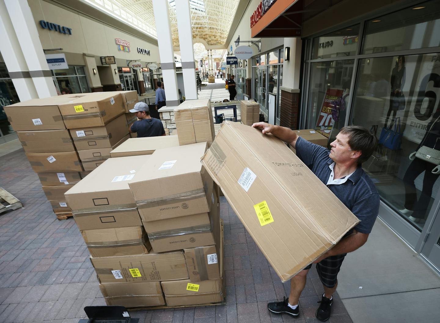 Bret Hueper right and his son Ben Hueper of City Sprint Courier unload boxes in front of Wilson Leather store at the outlet mall in Eagan Wednesday August 13 , 2014 in Eagan MN . ] Jerry Holt Jerry.holt@startribune.com