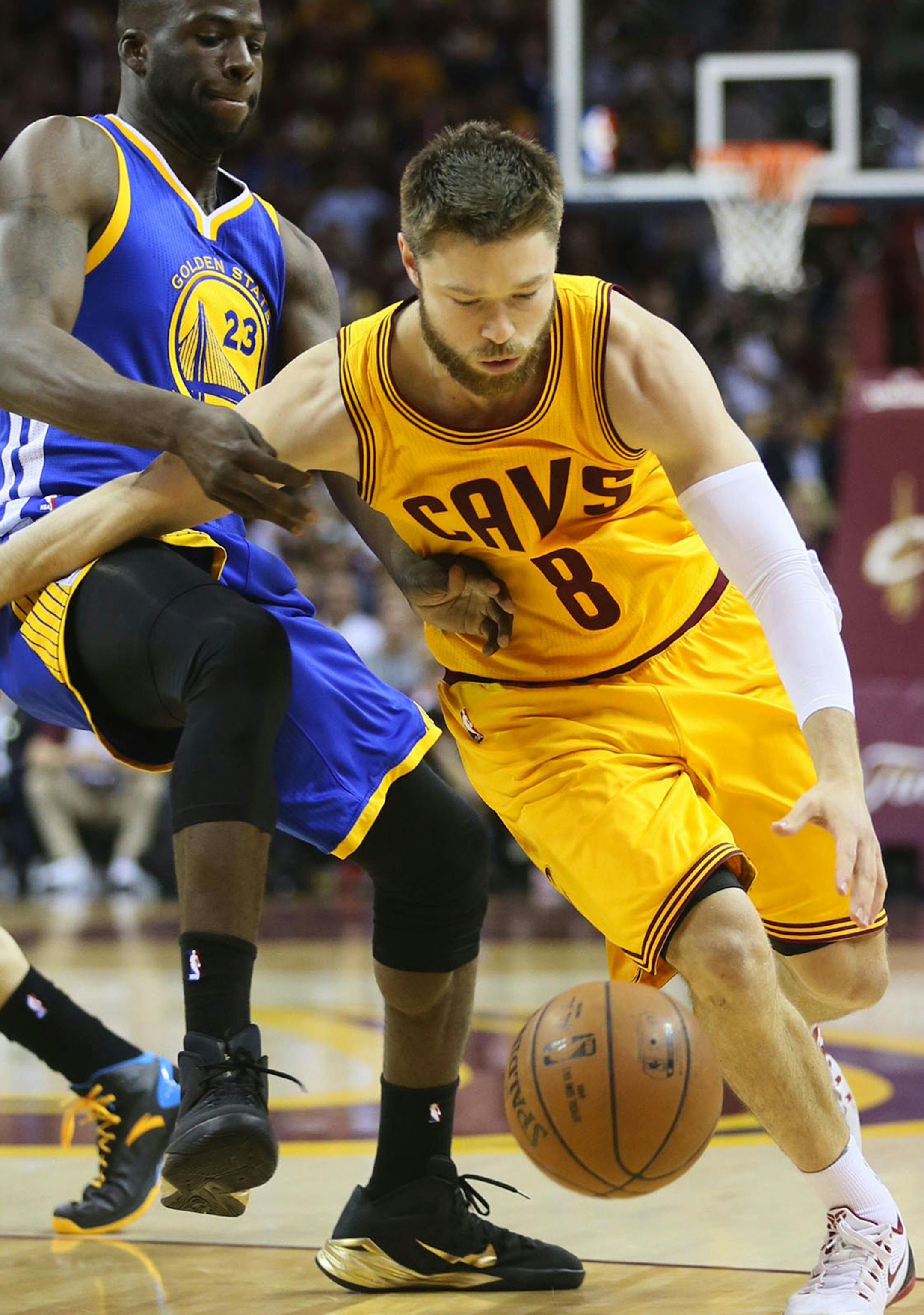 The Cleveland Cavaliers' Matthew Dellavedova, right, drives to the basket against the Golden State Warriors' Draymond Green during the first quarter in Game 3 of the NBA Finals at Quicken Loans Arena in Cleveland on Tuesday, June 9, 2015. (Ed Suba Jr./Akron Beacon Journal/TNS)