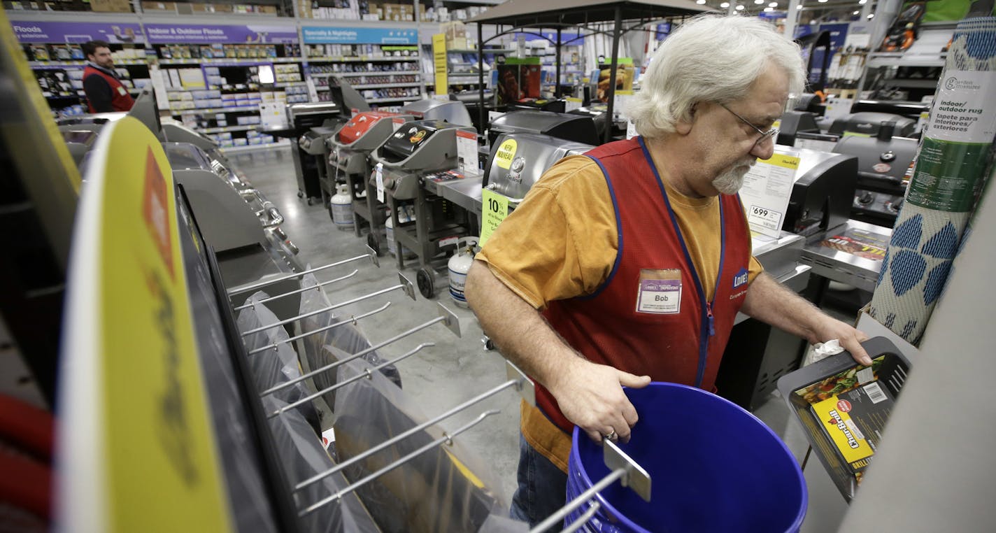 In this Friday, Feb. 23, 2018 photo sales associate Bob Henriques, of Framingham, Mass., places items on selves at a Lowe's retail home improvement and appliance store, in Framingham. (AP Photo/Steven Senne)