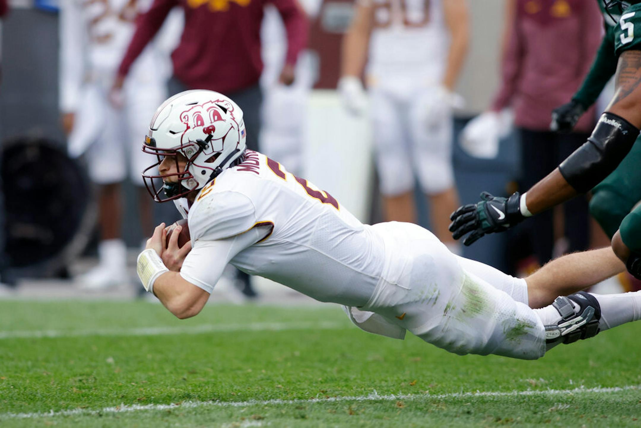 Minnesota quarterback Tanner Morgan dives for a first down against Michigan State during the second quarter of an NCAA college football game, Saturday, Sept. 24, 2022, in East Lansing, Mich. (AP Photo/Al Goldis)
