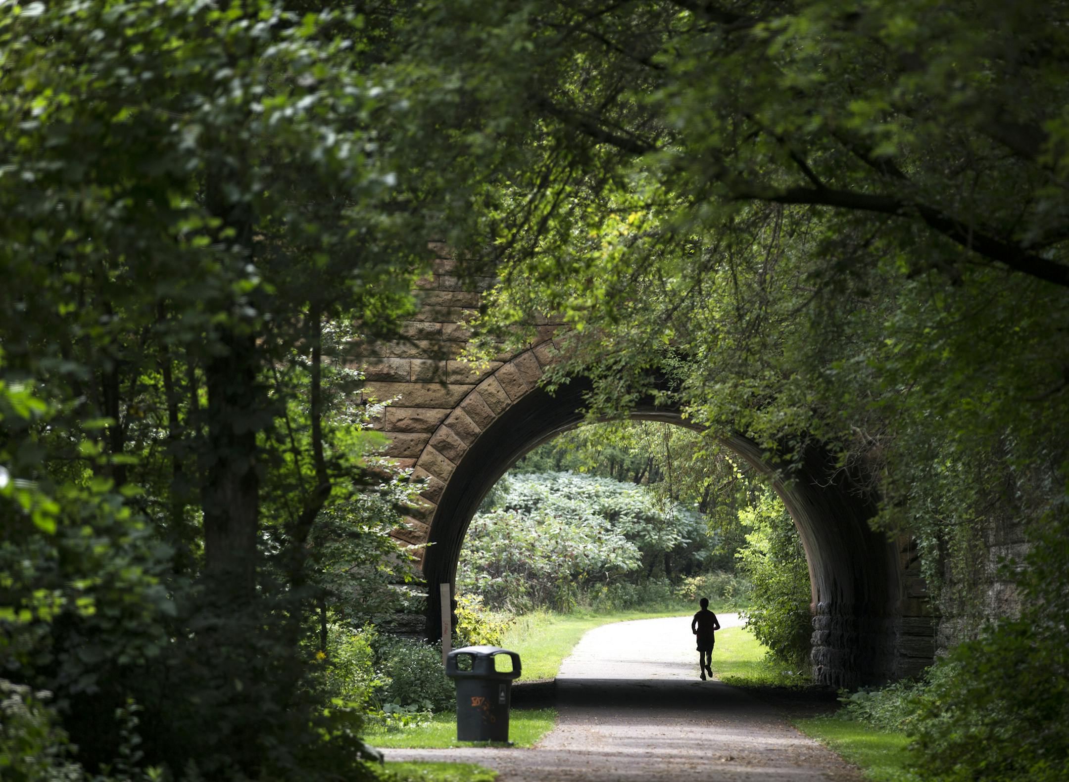 The biking and hiking paths in Swede Hollow Park are set in a secluded valley. Here, a jogger passed under the E. 7th Street bridge.
