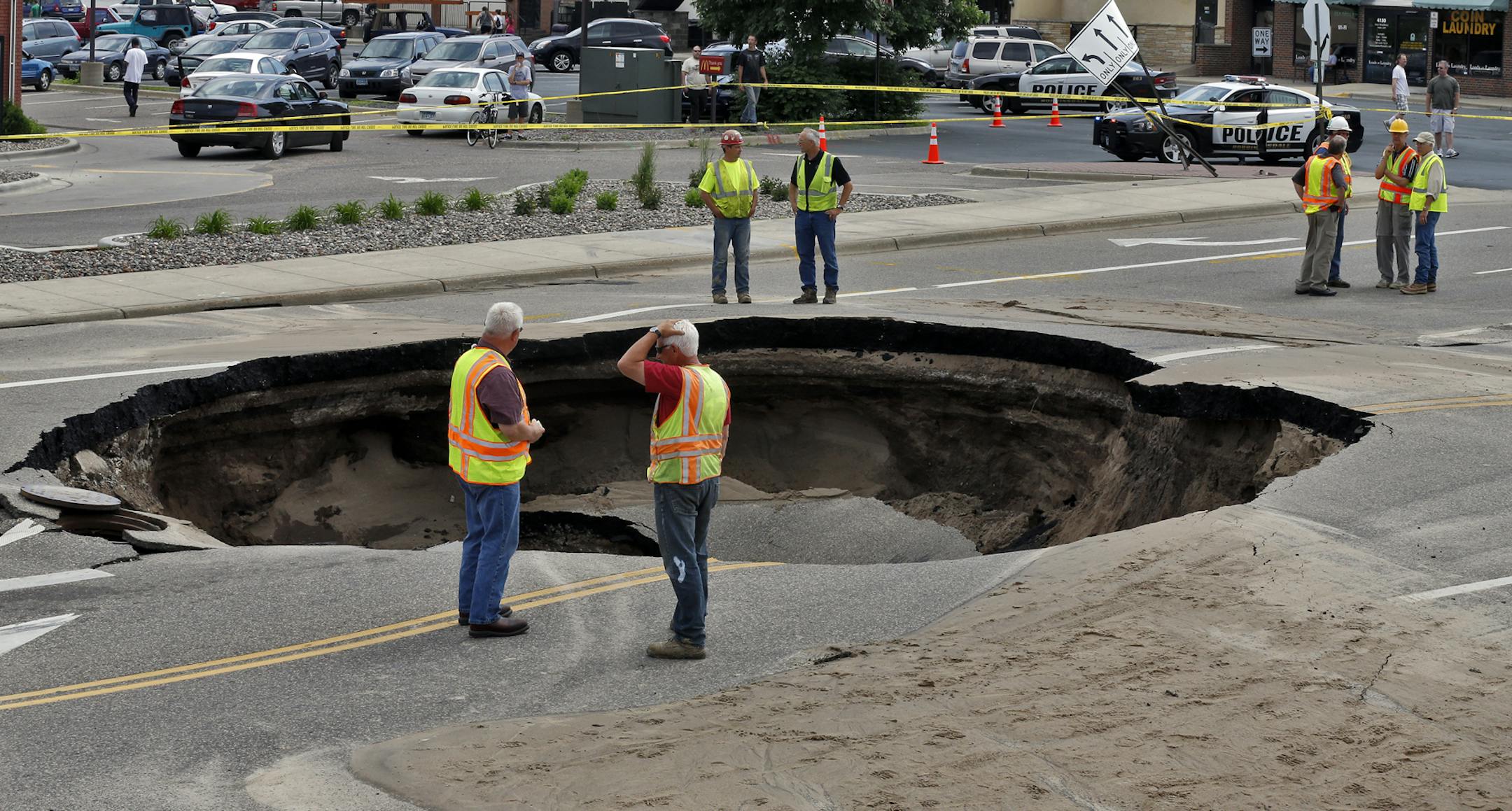 Sink hole in middle of 42 Ave. N. at Bottineau Blvd. caused by a broken water main. Robbinsdale city workers assess the damage done by the sink hole. (MARLIN LEVISON/STARTRIBUNE(mlevison@startribune.com (cq )