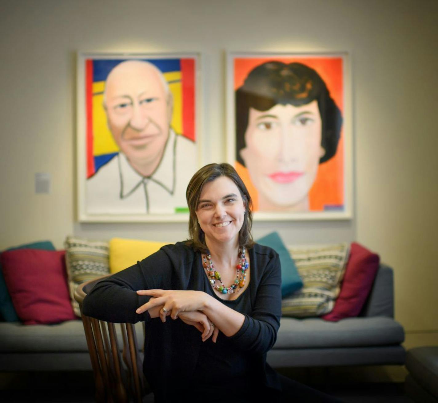 Jen Ford Reedy, the president of the Bush Foundation.Behind her are portraits of Archibald and Edyth Bassler Bush done by Bush Fellow Frank Gaard