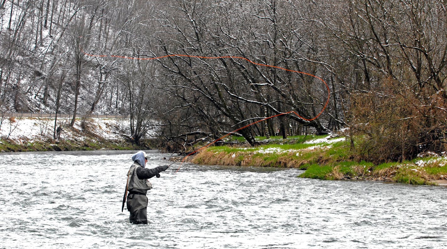 Snowl bracketed the swift waters of most southeastern Minnesota streams and rivers Saturday when the Minnesota stream trout season. Winterlike weather kept many anglers out of the water and close to home.