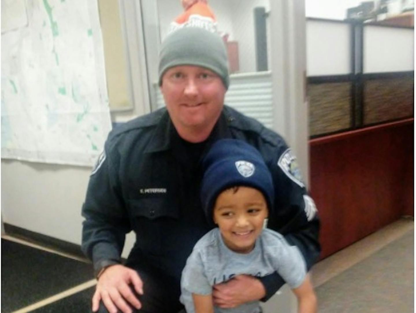 Mendota Heights police Sgt. Eric Petersen stands with 4-year-old Gabriel Abdirahman after the department threw the boy a surprise birthday party.