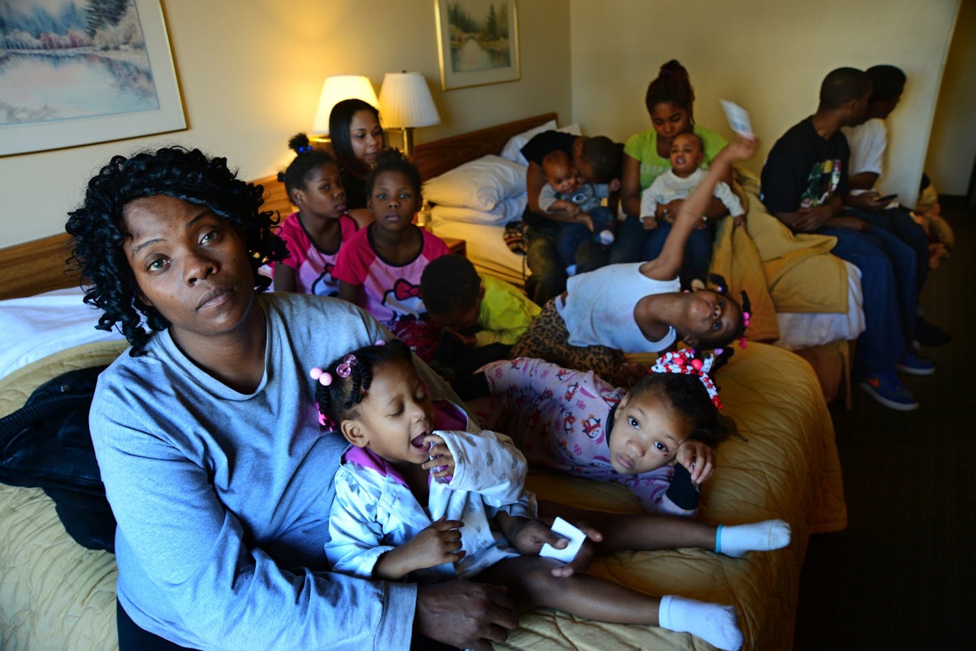 LaDonna Harris sat on a bed at the Comfort Inn in Brooklyn Center after the Red Cross arranged for six rooms for her and 23 of her family members who were uprooted by a duplex fire early Tuesday. Harris said she moved into the duplex last month to get away from gunfire in a neighborhood farther north.