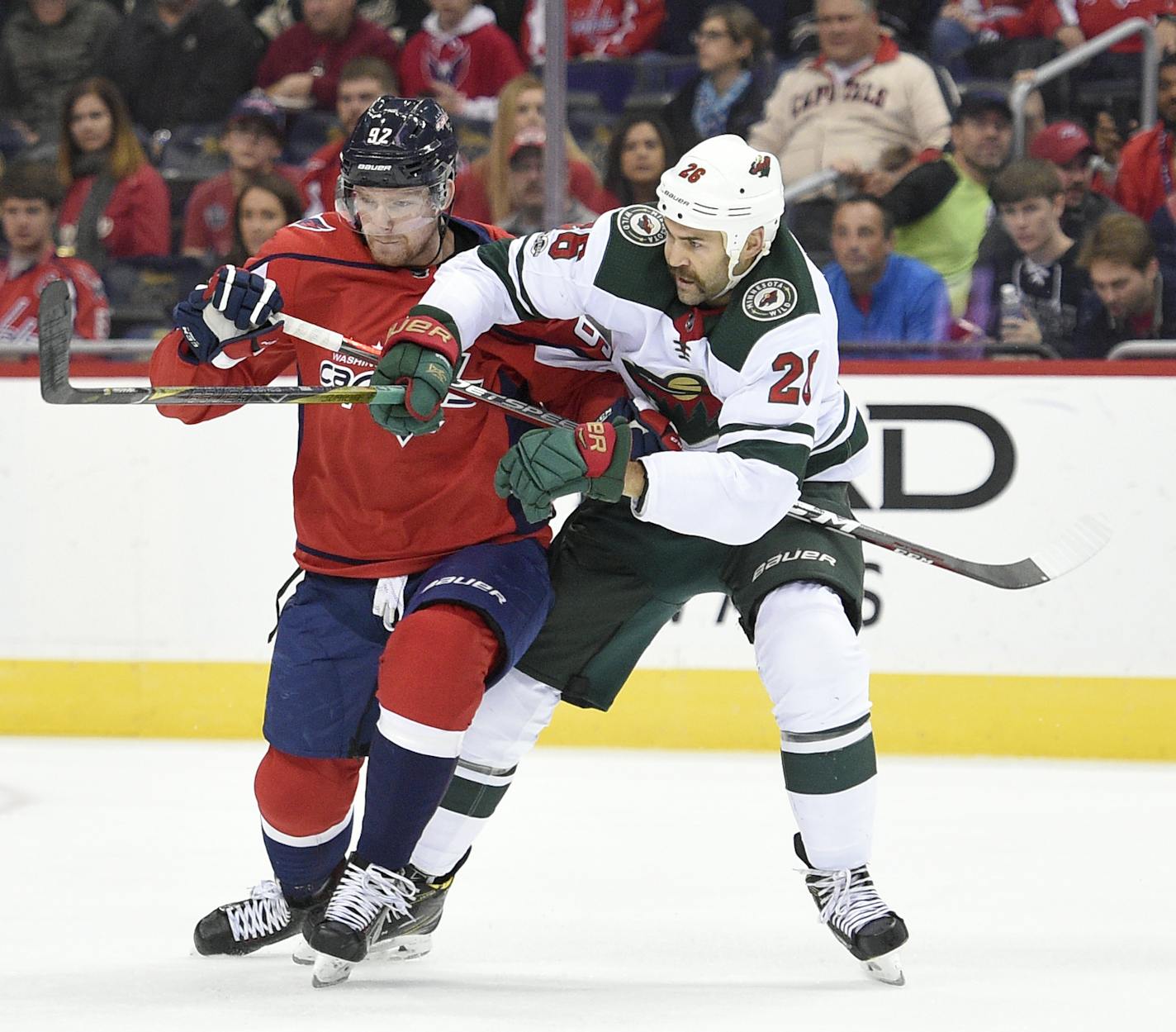 Minnesota Wild left wing Daniel Winnik (26) tangles with Washington Capitals center Evgeny Kuznetsov (92), of Russia, during the first period of an NHL hockey game, Saturday, Nov. 18, 2017, in Washington. (AP Photo/Nick Wass)