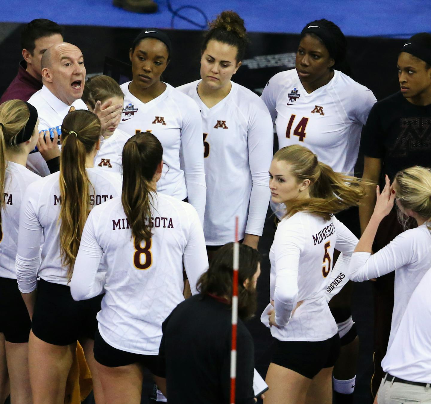 Minnesota coach Hugh McCutcheon, left, talks to his players during a timeout in an NCAA women's volleyball tournament semifinal against Texas in Omaha, Neb., Thursday, Dec. 17, 2015. (AP Photo/Nati Harnik)