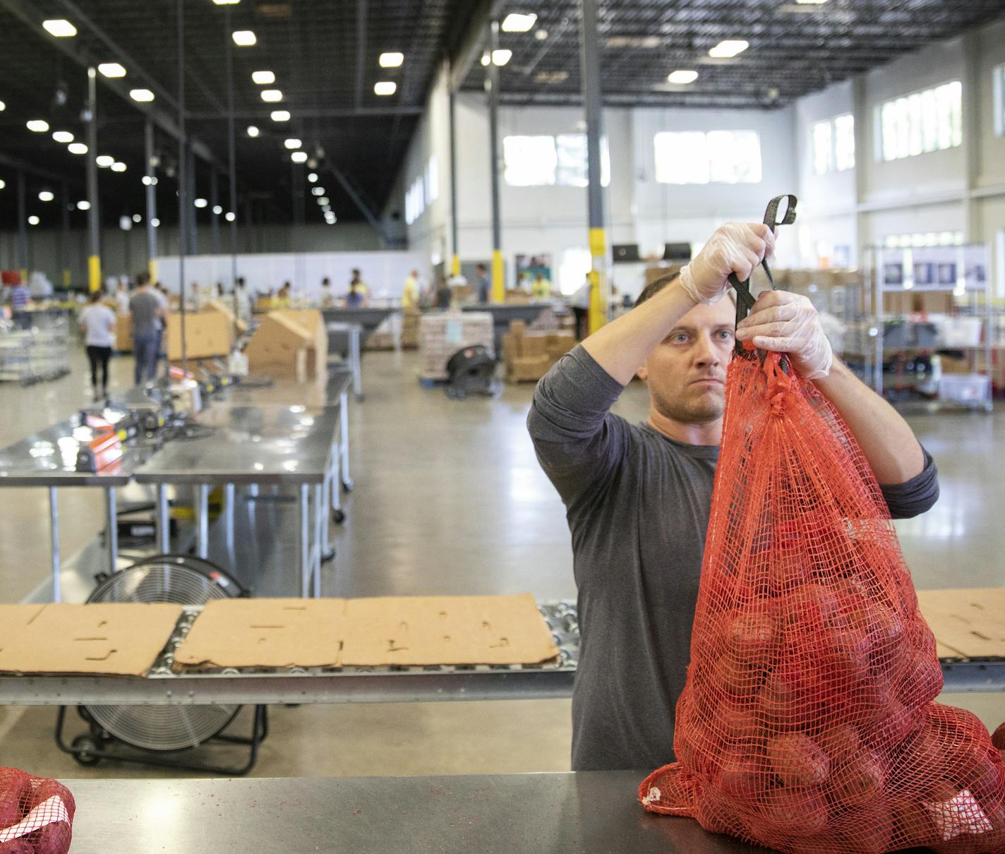 Volunteer Josh Benjamin with Wells Fargo bags potatoes.