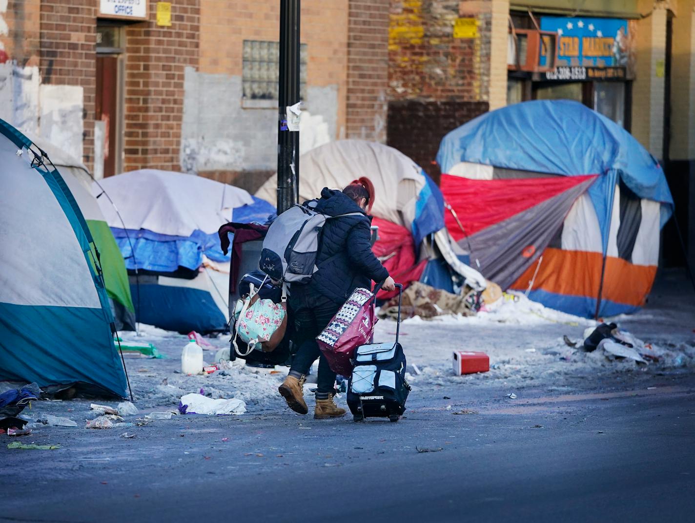 A former resident of a homeless encampment along Bloomington Ave. S., near 26th St. E. moves her belongings before city officials cleared the camp Thursday, Jan. 13, 2022, in Minneapolis, Minn. ] DAVID JOLES • david.joles@startribune.com