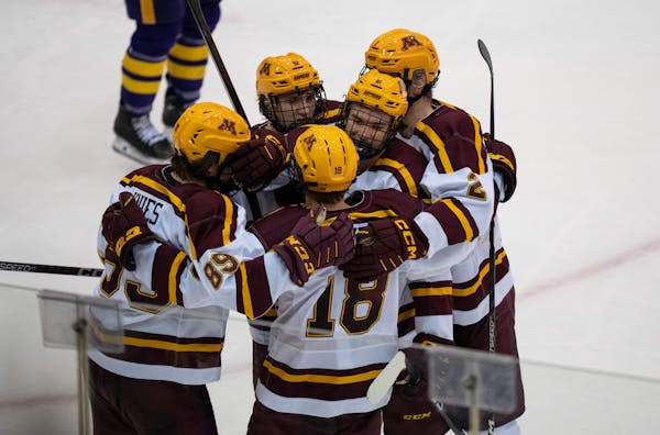 Teammates celebrate with Minnesota forward Jimmy Snuggerud (81) (center) who had just scored his third goal of the game in the third period.