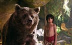 In this image released by Disney, Mowgli, portrayed by Neel Sethi, right, and Baloo the bear, voiced by Bill Murray, appear in a scene from, "The Jung