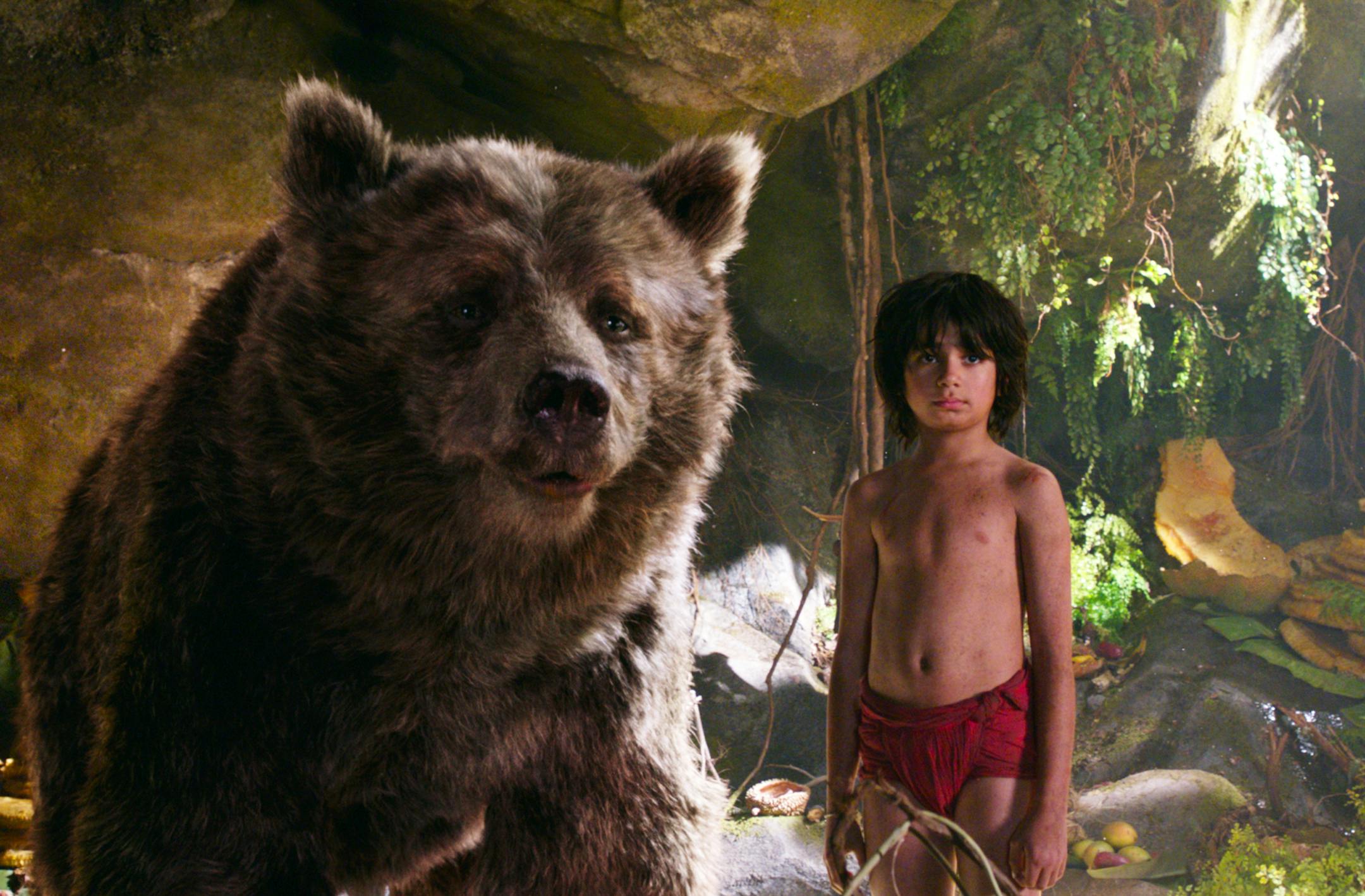 In this image released by Disney, Mowgli, portrayed by Neel Sethi, right, and Baloo the bear, voiced by Bill Murray, appear in a scene from, "The Jungle Book." (Disney via AP)