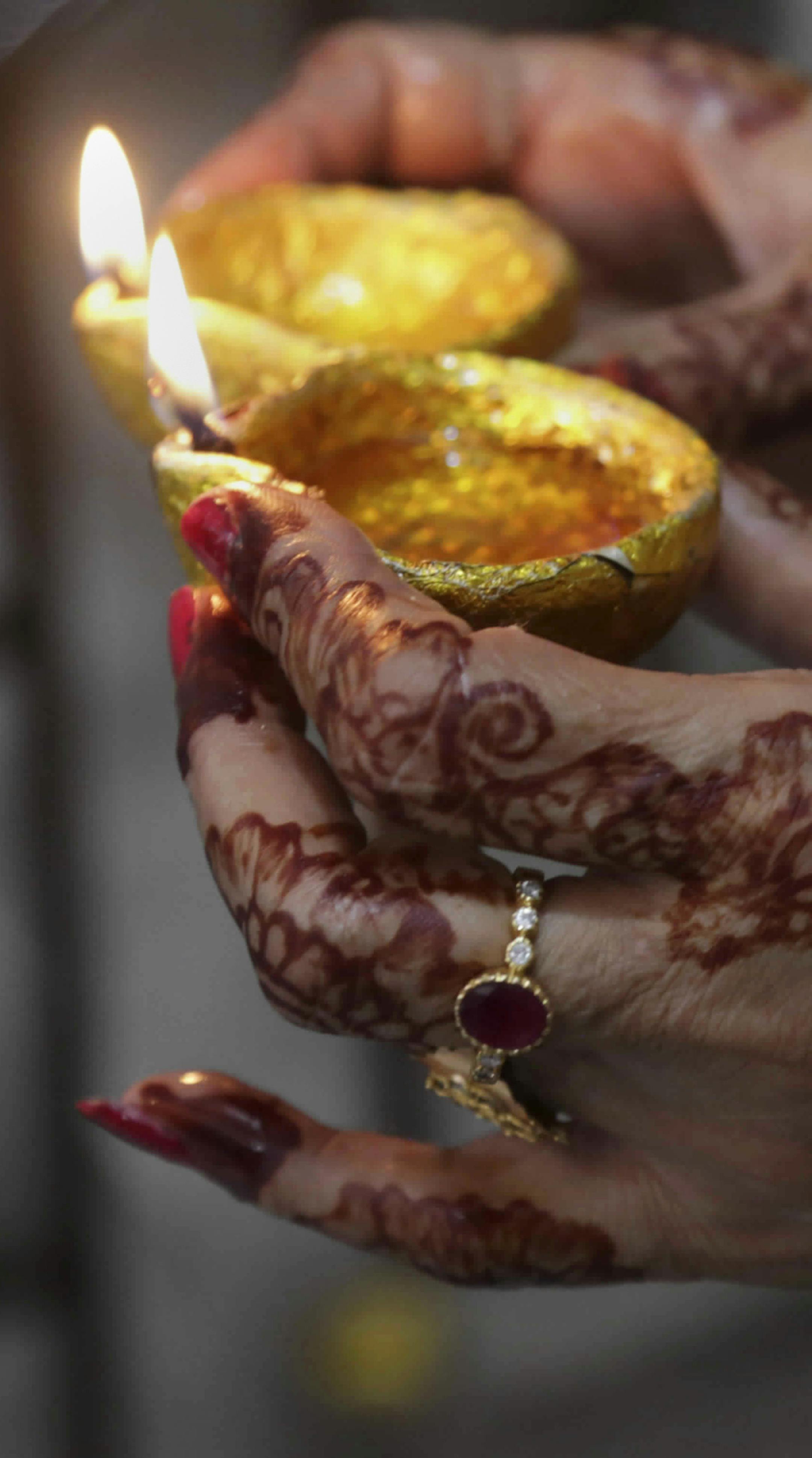 A Pakistani Hindu woman holds oil lamps to celebrate Diwali, the Hindu festival of lights, in Lahore, Pakistan, Thursday, Oct. 19, 2017. (AP Photo/K.M. Chaudary)