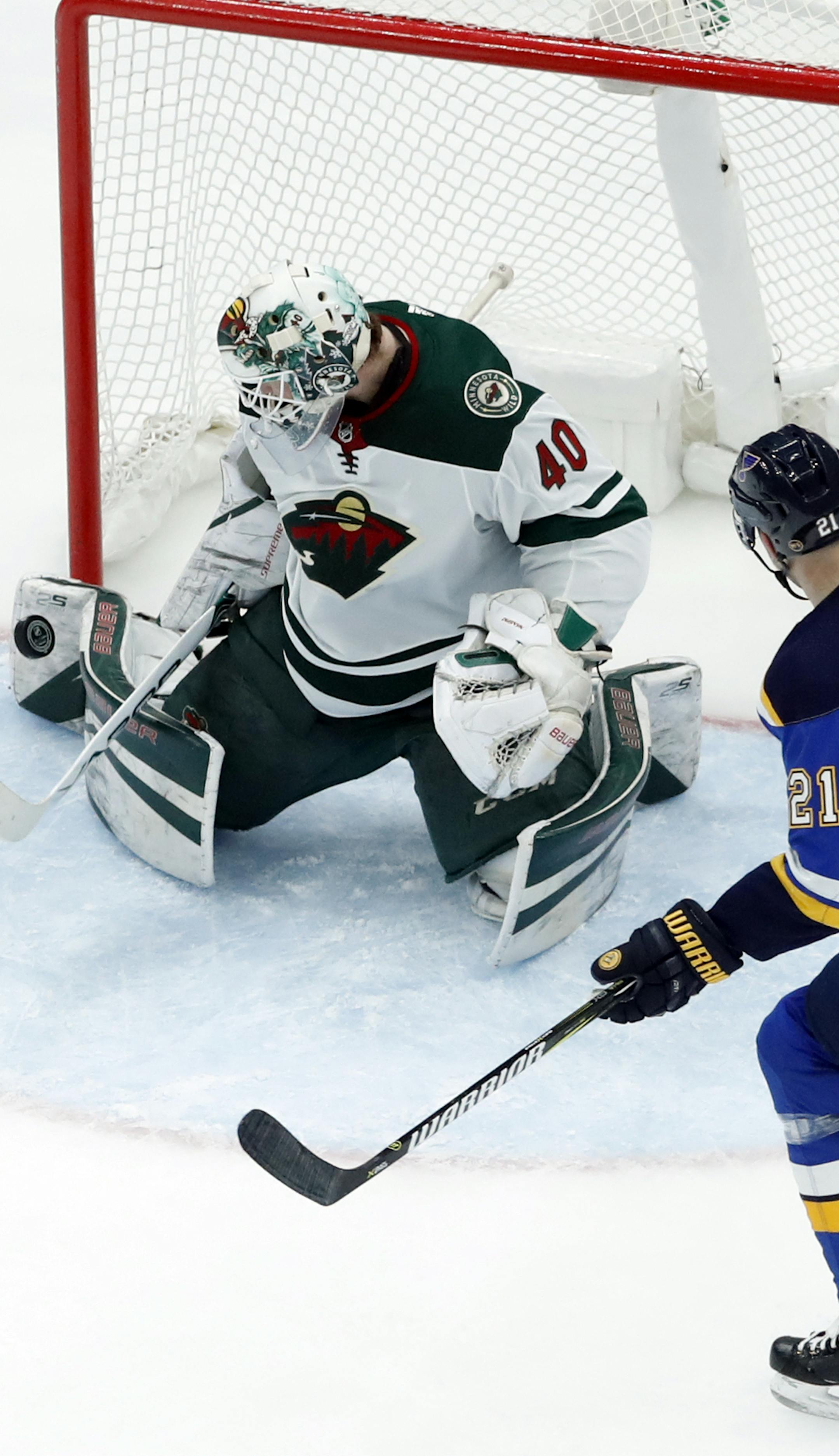 Minnesota Wild goaltender Devan Dubnyk, left, deflects a puck as St. Louis Blues' Patrik Berglund, of Sweden, watches during the third period of an NHL hockey game Tuesday, Feb. 6, 2018, in St. Louis. The Wild won 6-2. (AP Photo/Jeff Roberson)