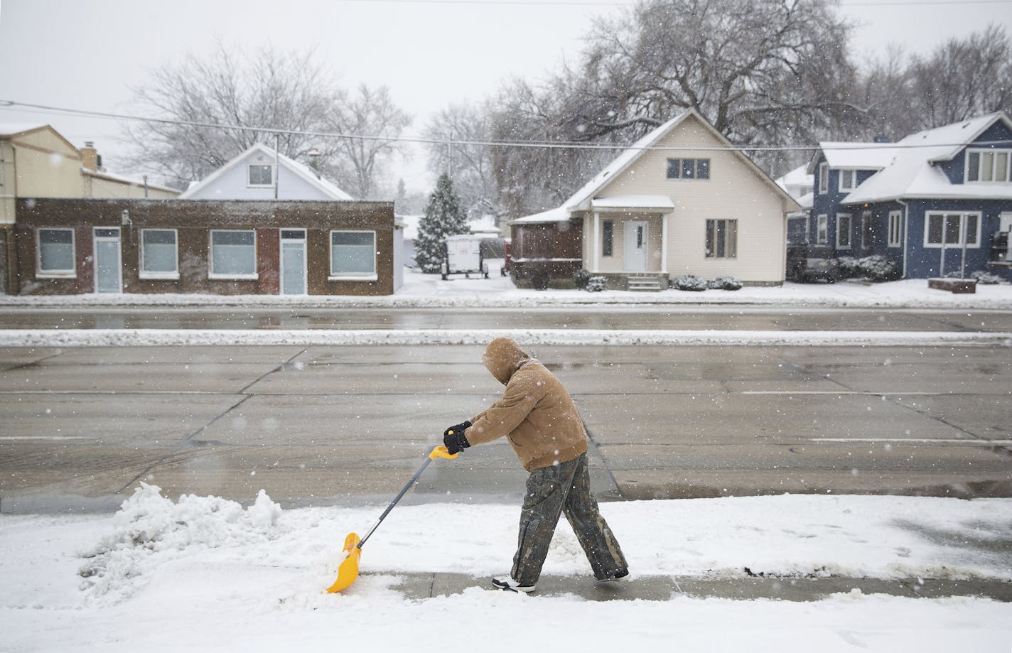 Mickey Robinson shovels snow and ice from the sidewalk Friday, Feb 24, 2017, in Omaha, Neb. A slow-moving storm has dropped nearly 2 feet of snow in western Nebraska as it moves east through Iowa, covering highways and making travel treacherous. (Rebecca Gratz/The World-Herald via AP)