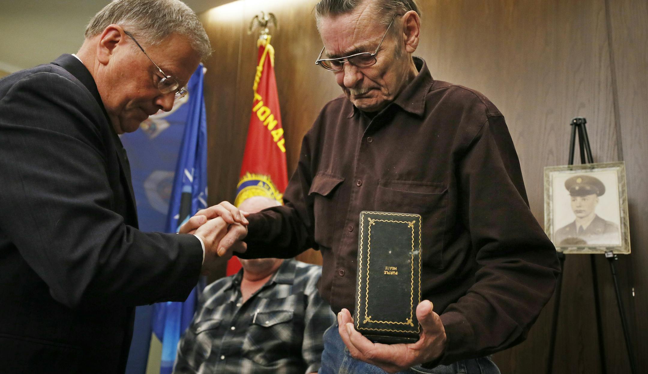 Minnesota Department of Veterans Affairs Commissioner Larry Shellito, left, presented William Johnson with the Purple Heart medal that his deceased brother earned in Korea.