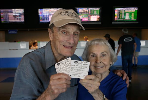 Harold Walter and his wife, Catherine, display their $2 advance wagers they placed on California Chrome, at the CalExpo racetrack in Sacramento,Calif.