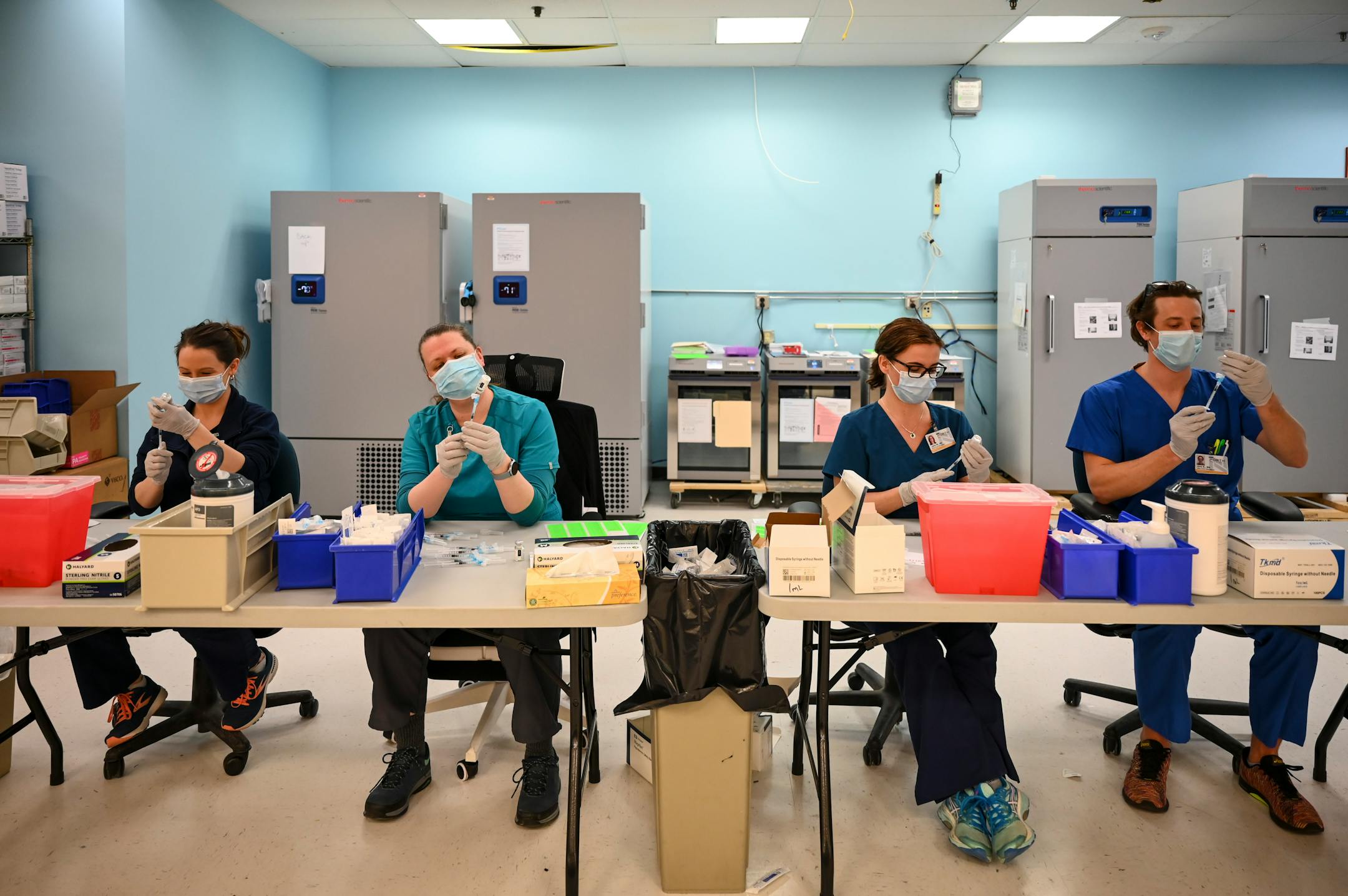 From left, Blue Cross and Blue Shield of Minnesota nurses Alison Stumne, Tamara Pierre,  Jana Wagner and Kirk Randall filled syringes with the Moderna COVID-19 vaccine at a North Memorial Health Hospital vaccination clinic in Brooklyn Center.