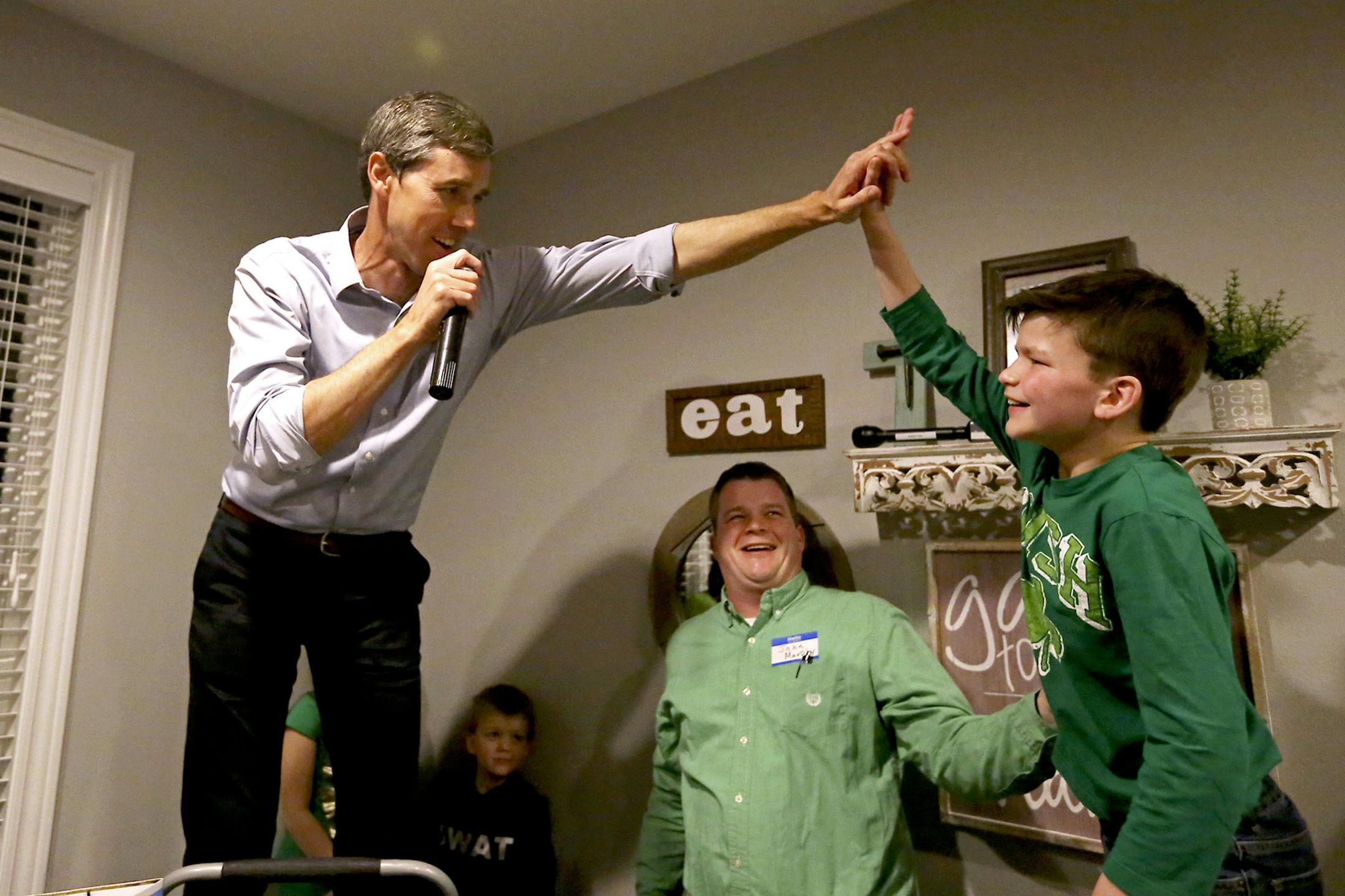 Democratic presidential candidate Beto O'Rourke high-fives Mitchell Murphy, 12, while he speaks at an event at the home of Dubuque County Recorder John Murphy in Dubuque, Iowa on Saturday, March 16, 2019. (Eileen Meslar/Telegraph Herald via AP)