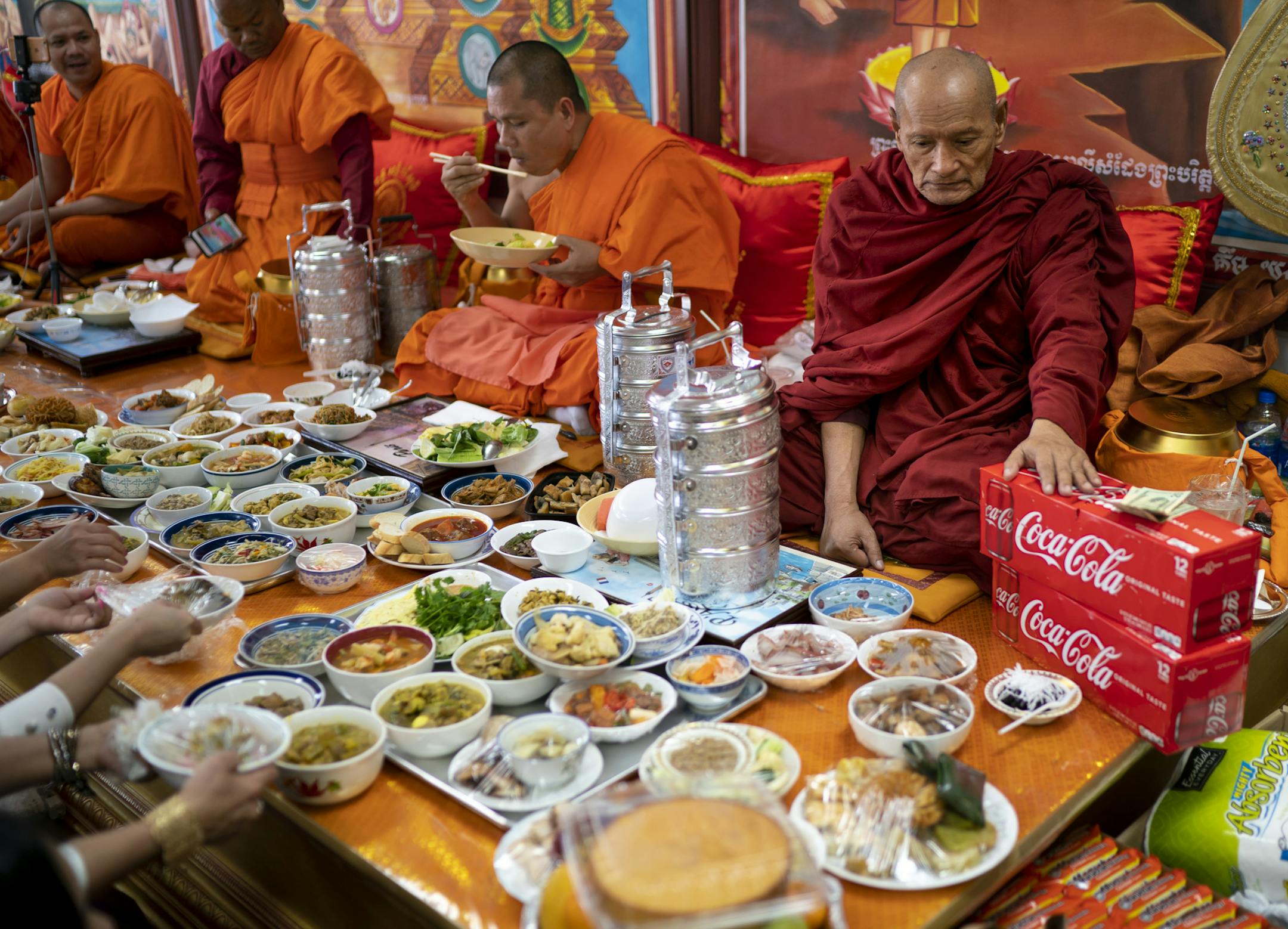 Venerable Seng Bun Sang put his hands on a case of beverages to bless them for the later meal as many visitors brought food offerings to the monks during the Cambodian New Year celebration at Watt Munisotaram Temple in Hampton, Minn., on Sunday, April 14, 2019. At his left is Venerable Moeng Sang. ] RENEE JONES SCHNEIDER ¥ renee.jones@startribune.com