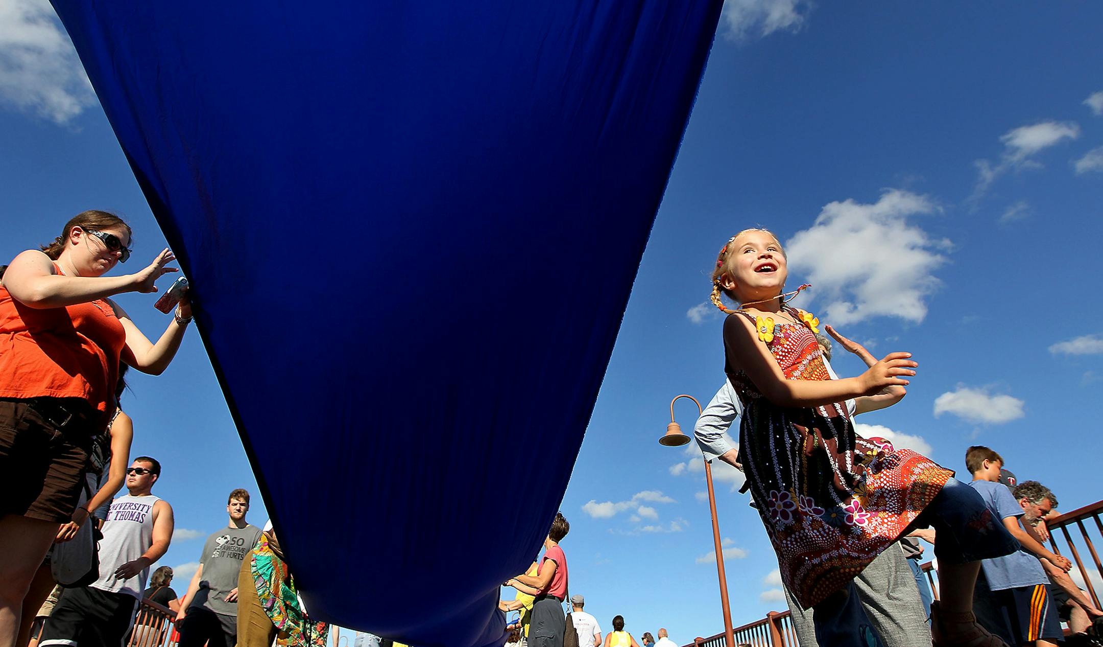 Brigid Halonen, cq, 6, danced beneath and alongside a banner representing the Mississippi River atop the Stone Arch Bridge during the Solstice River XIX & Global Water Dances, Saturday, June 20, 2015 in Minneapolis, MN. She was there with her mother Michelle Halonen, left. The one-day event, which includes dancers performing in the area including the lock and dam, illuminates water issues through the art of dance around the world. ] (ELIZABETH FLORES/STAR TRIBUNE) ELIZABETH FLORES &#x2022; eflor