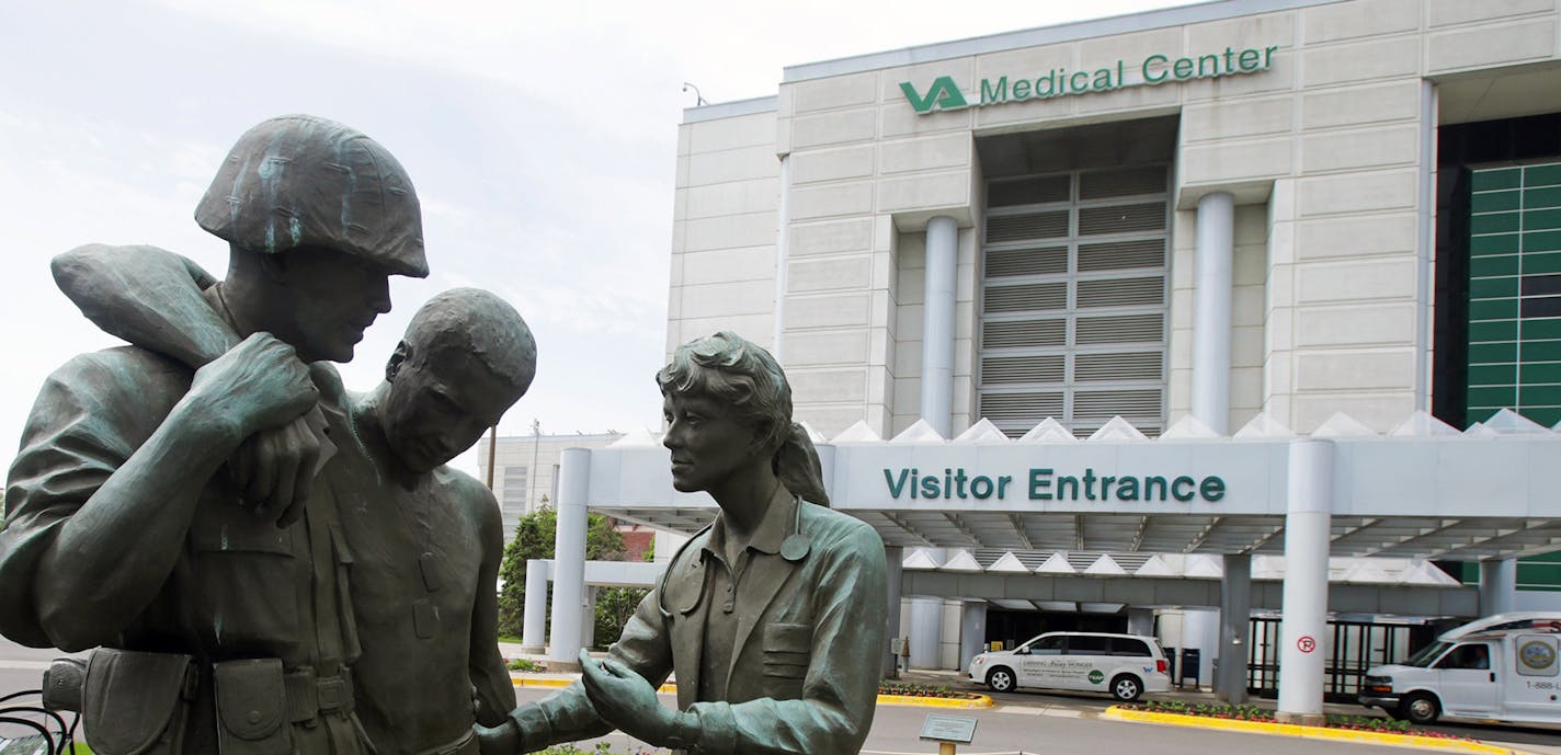 FILE - In this June 9, 2014 file photo is a sculpture portraying a wounded soldier being helped on the grounds of the Minneapolis VA Hospital. Minnesota&#xed;s Veterans Affairs clinics and hospitals fare slightly better in delivering timely care to veterans than the national average between September and February, according to six months of appointment data analyzed by the Associated Press. (AP Photo/Jim Mone, File) ORG XMIT: MIN2015051314130372