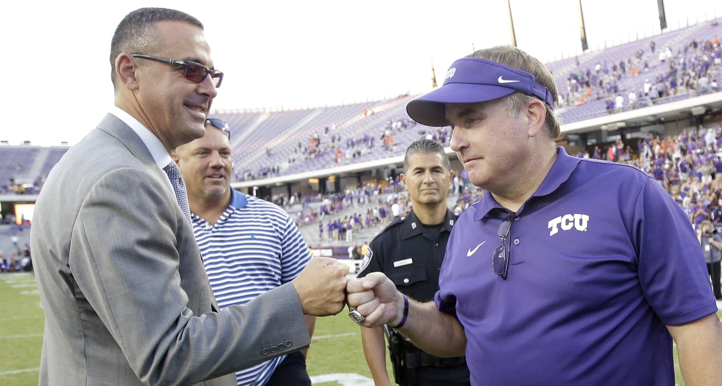 TCU Athletic Director Chris Del Conte bumps fist with head coach Gary Patterson following their NCAA college football game against Oklahoma State, Saturday, Oct. 18, 2014, in Fort Worth, Texas. TCU won 42-9. (AP Photo/Tony Gutierrez) ORG XMIT: TXTG118