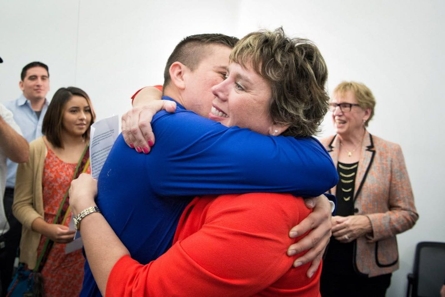 Judge Anne McKeig hugged her son Balam after she was appointed to the Minnesota Supreme Court. Behind her are son Xicotencatl, daughter Itzel and, on the right, her mother, Cecelia.