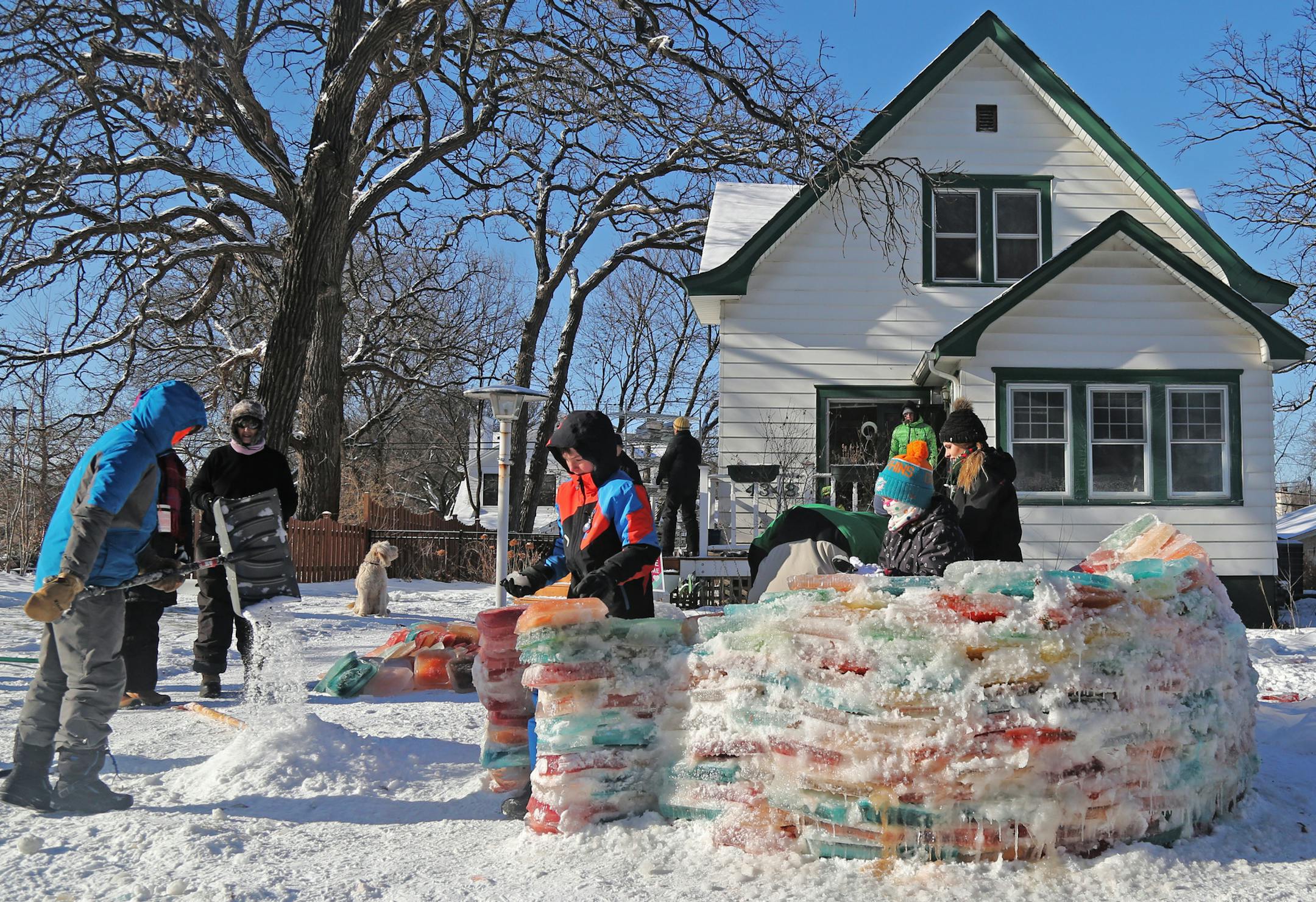 Martha Palm, her family and some former students of hers will be working on the multi-colored igloo they are building at the Palms' south Minneapolis home and seen Saturday, Dec. 30, 2017, in Minneapolis, MN. Here, a mixture of snow and water was mixed together to form the mortar to bond the ice blocks together. Members of the Palm and Zirps family as well as Martha's Palm's former students and neighbors built the igloo.] DAVID JOLES &#xef; david.joles@startribune.com What's a kid to do during t