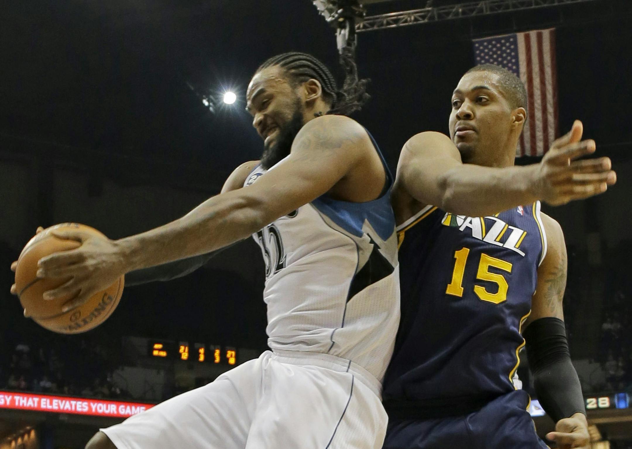 Minnesota Timberwolves center Ronny Turiaf, left, of France, pulls down a rebound against Utah Jazz center Derrick Favors (15) during the second quarter of an NBA basketball game in Minneapolis, Wednesday, April 16, 2014. (AP Photo/Ann Heisenfelt)