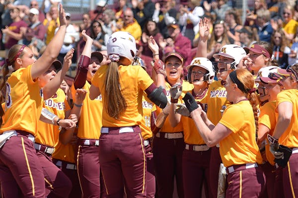 Teammates celebrated with Minnesota infielder Makenna Partain (3) after Partain's grand slam against Wisconsin in a game last month.
