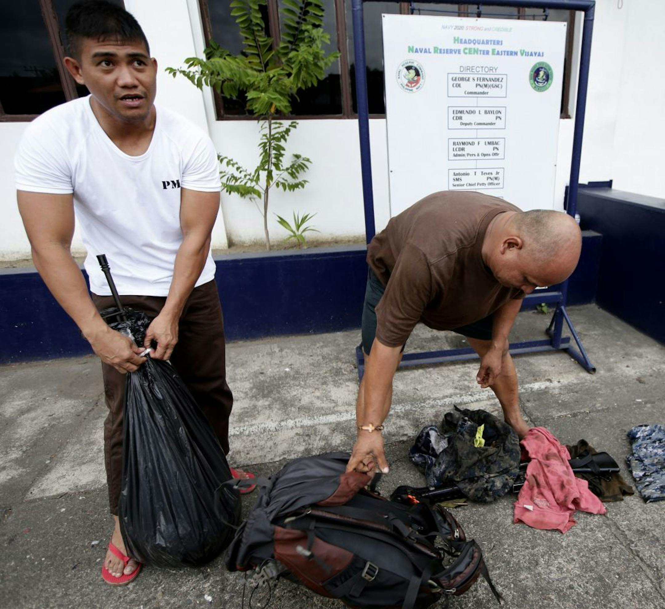 Navy marshal Richard Pestillos, left, of the Philippine Navy and Joseph Austria of the Philippine Coast Guard, show their M-16 rifles and other items they saved as they recount to the Associated Press Sunday Aug.18, 2013 in Cebu city, central Philippines how they saved the lives of about two dozen passengers of the ill-fated MV Thomas Aquinas when it collided with the cargo ship Sulpicio Express Siete off the coast of Talisay near Cebu Friday. Pestillos and Austria, both "sea marshals" of the fe