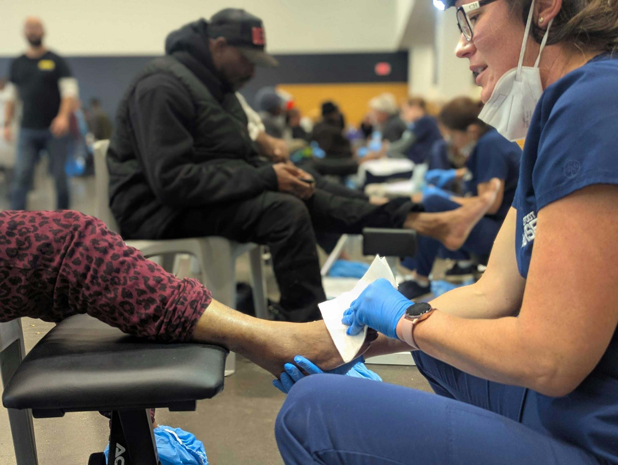 Volunteers offer footcare for vulnerable Minnesotans at Catholic Charities' "Our Hearts To Your Soles" event where Red Wing Shoes donated hundreds of shoes and socks.