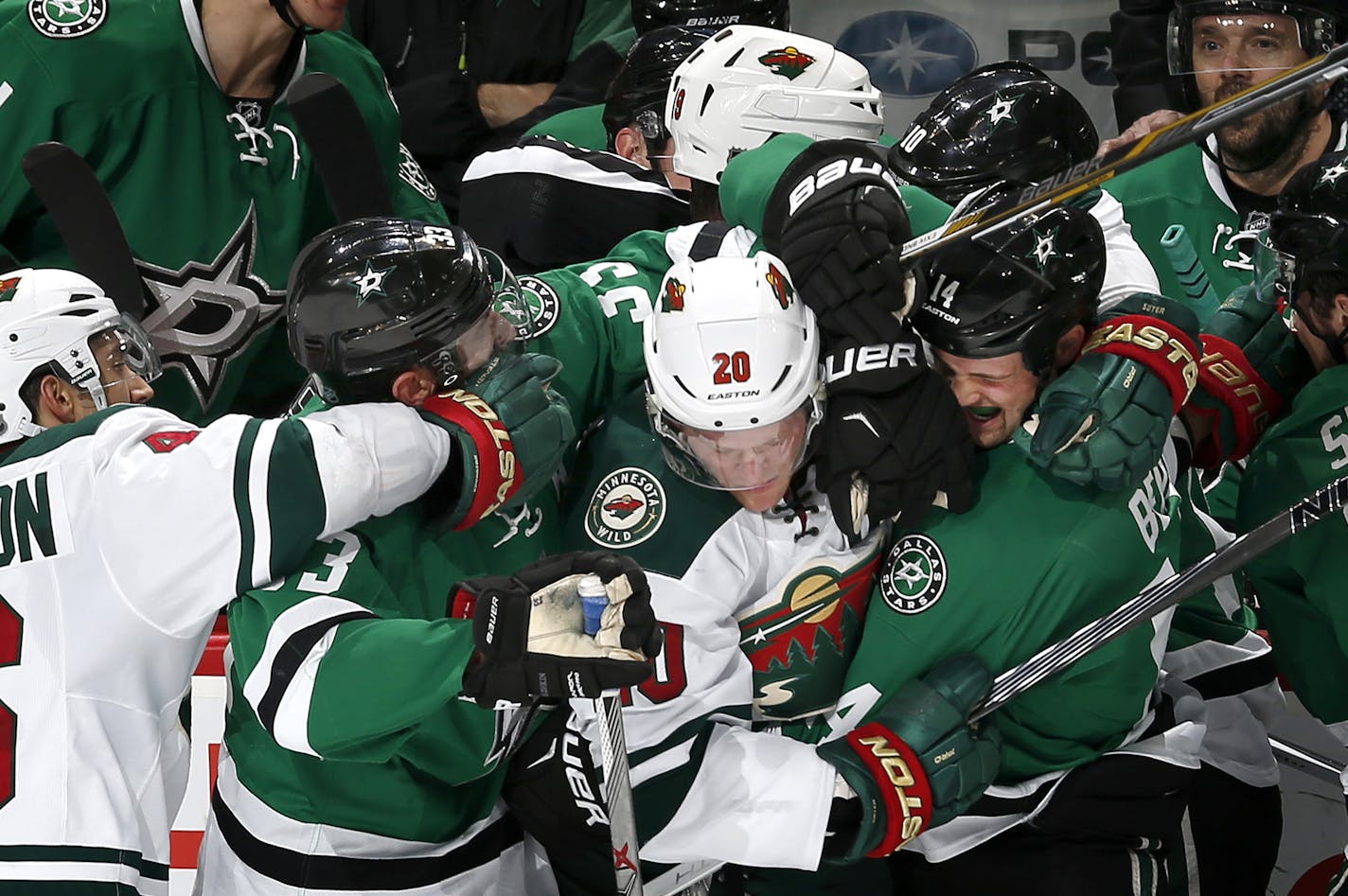 Jared Spurgeon (46), Jarret Stoll (19) and Ryan Suter tangled up with Stars players in front of the Dallas bench in the second period.