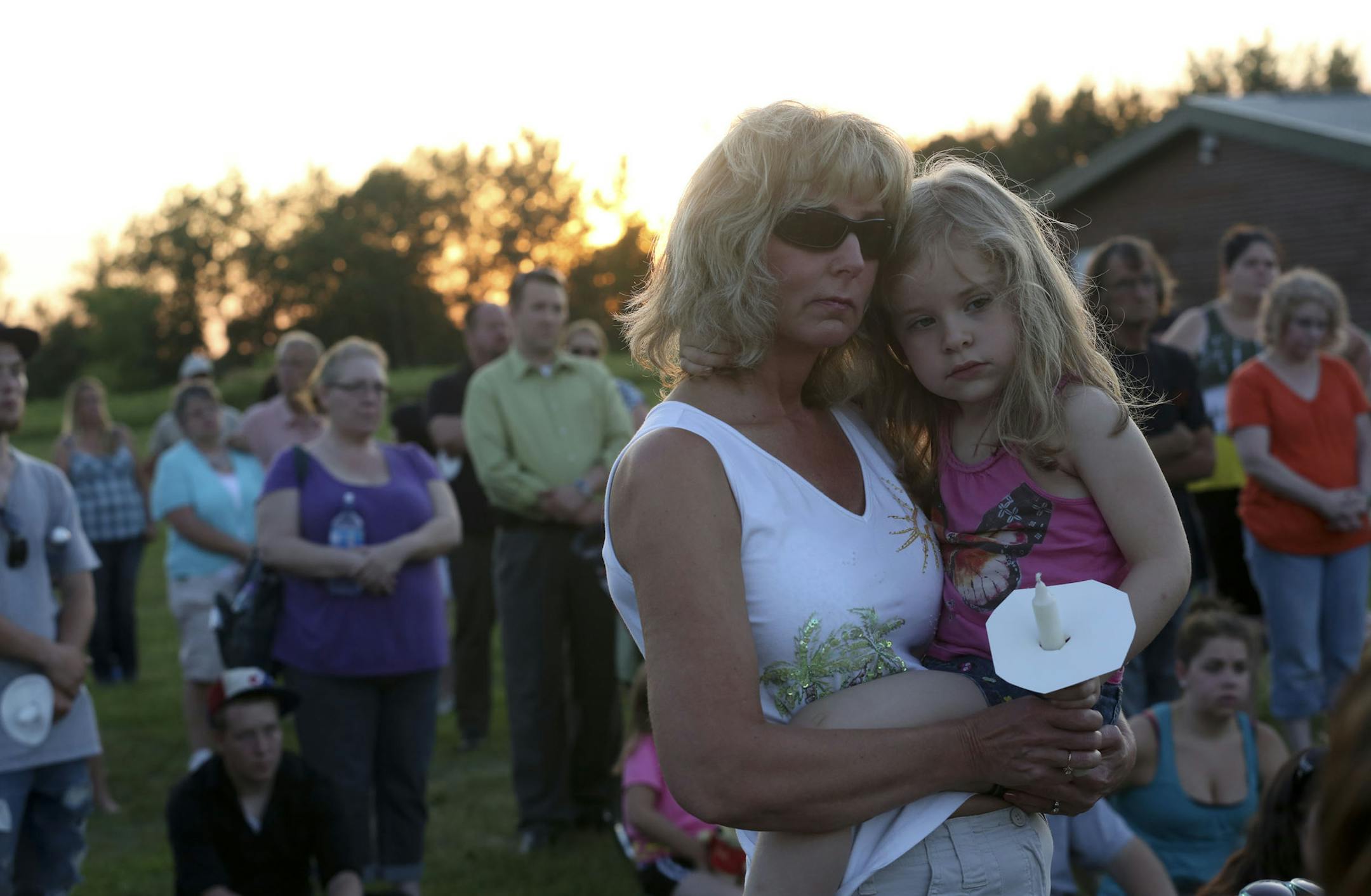 Karen Murphy held her granddaughter Liliana Kolb,4, during a vigil for 2-year-old Isaiah Theis, whose body was found in a locked car in Centuria, Wis.